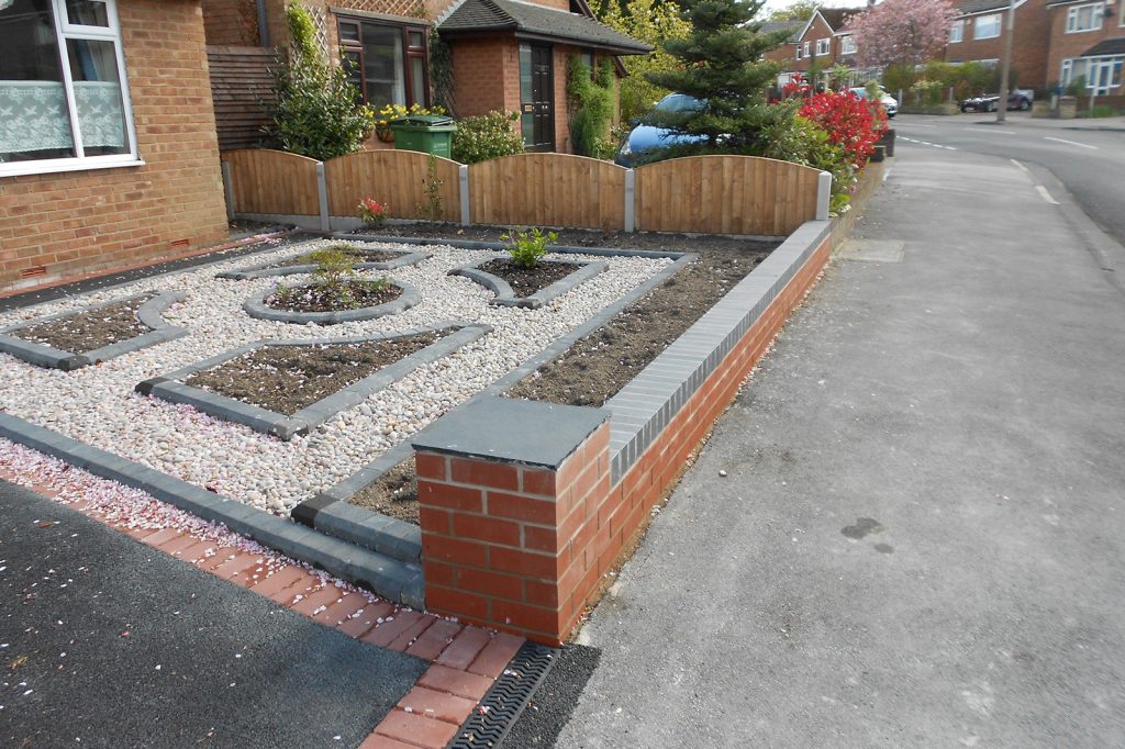 Red brick garden wall with engineering bricks to top
