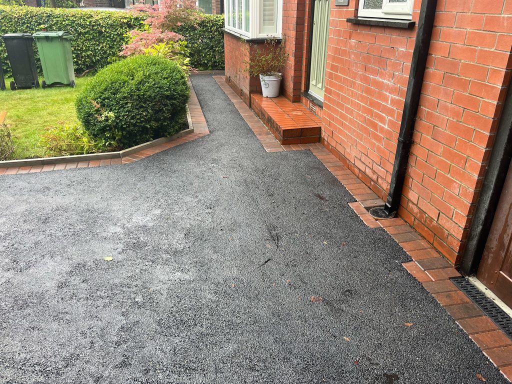 Tarmac pathway leading to front door with red brick border