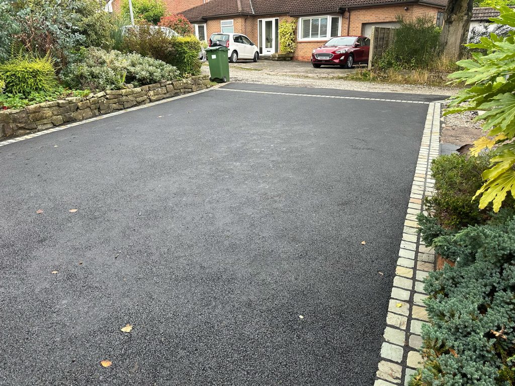 Finished job with stunning pewter cobblestones and a sleek tarmac driveway